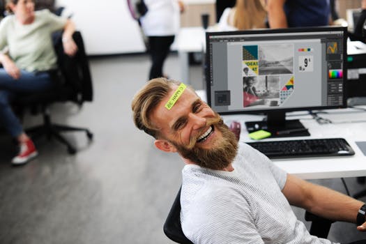 man at desk smiling and happy in 2018